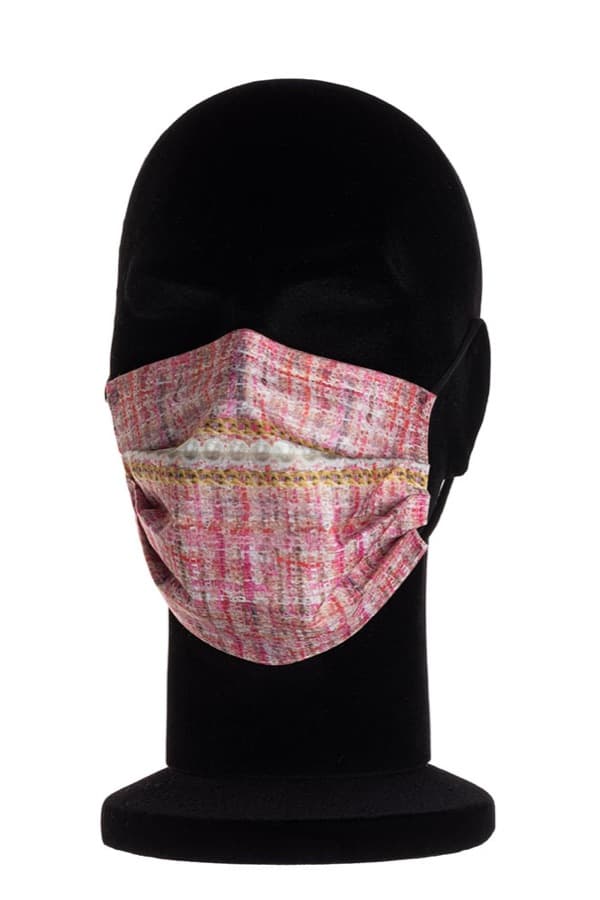 Mascherina chirurgica Silky Touch in tweed rosa con una fascia di perle e catena dorata, su un manichino nero.